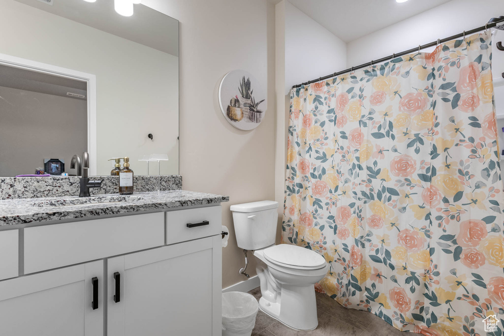 Full bath with vanity, toilet, tile patterned flooring, curtained shower, and baseboards