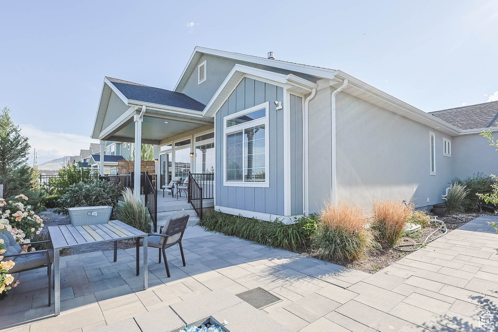 Rear view of house with a patio, outdoor dining space, and stucco siding