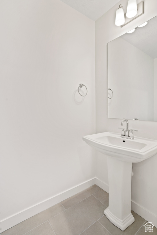 Bathroom with baseboards and tile patterned floors