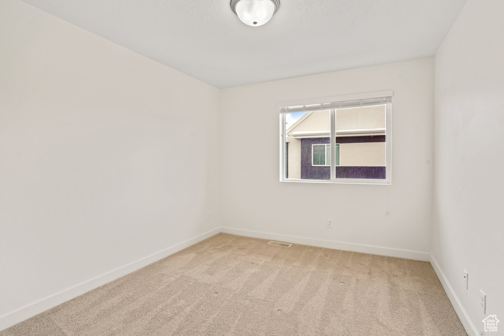 Unfurnished room with light carpet and baseboards