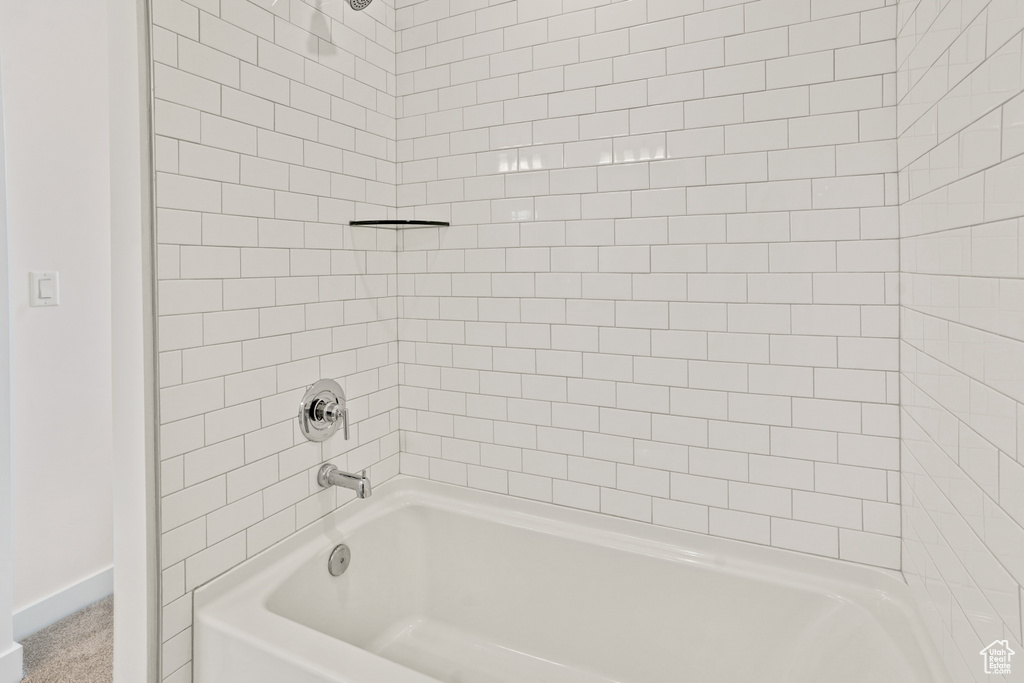 Bathroom featuring shower / washtub combination and baseboards