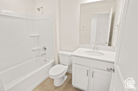 Full bathroom with toilet, vanity, and shower / tub combination