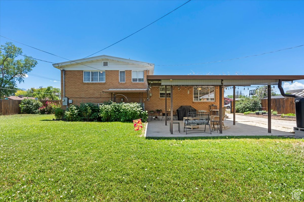 Back of house with a patio and brick siding