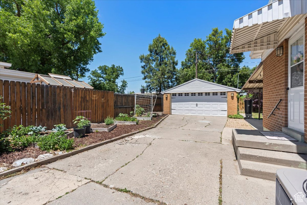 View of yard featuring a detached garage and an outbuilding