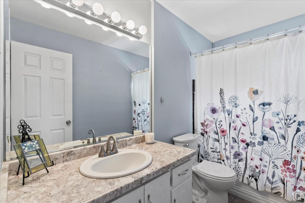 Bathroom with vanity, toilet, and a shower with curtain