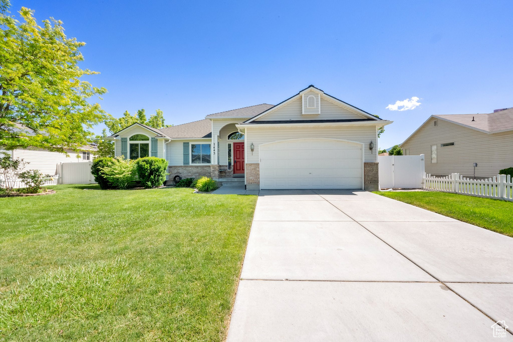 Ranch-style home featuring a garage and driveway