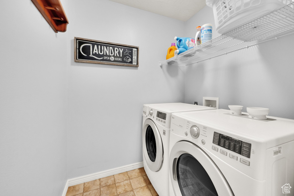 Washroom featuring baseboards and separate washer and dryer