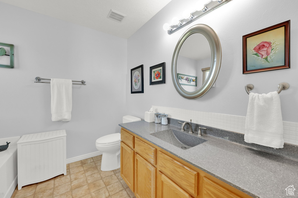 Bathroom with vanity, radiator heating unit, and a tub to relax in