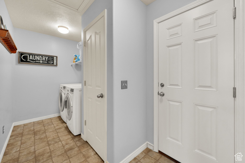 Laundry room with separate washer and dryer and a textured ceiling