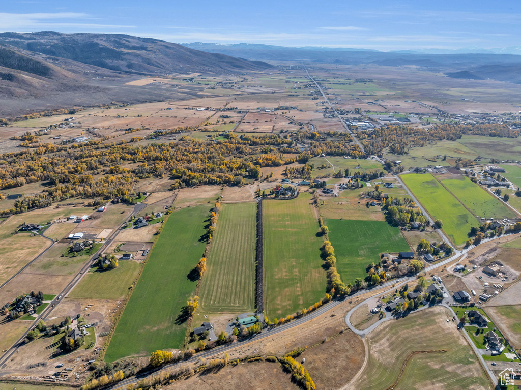 Aerial view of property and surrounding area featuring mountains and rural landscape