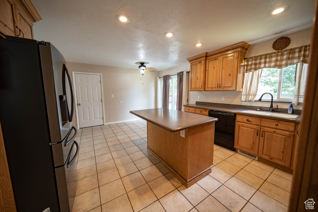 Kitchen featuring stainless steel fridge, black dishwasher, a center island, recessed lighting, and light tile patterned flooring