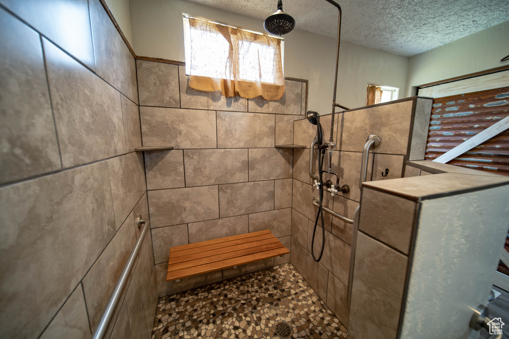 Bathroom featuring a textured ceiling and a walk in shower