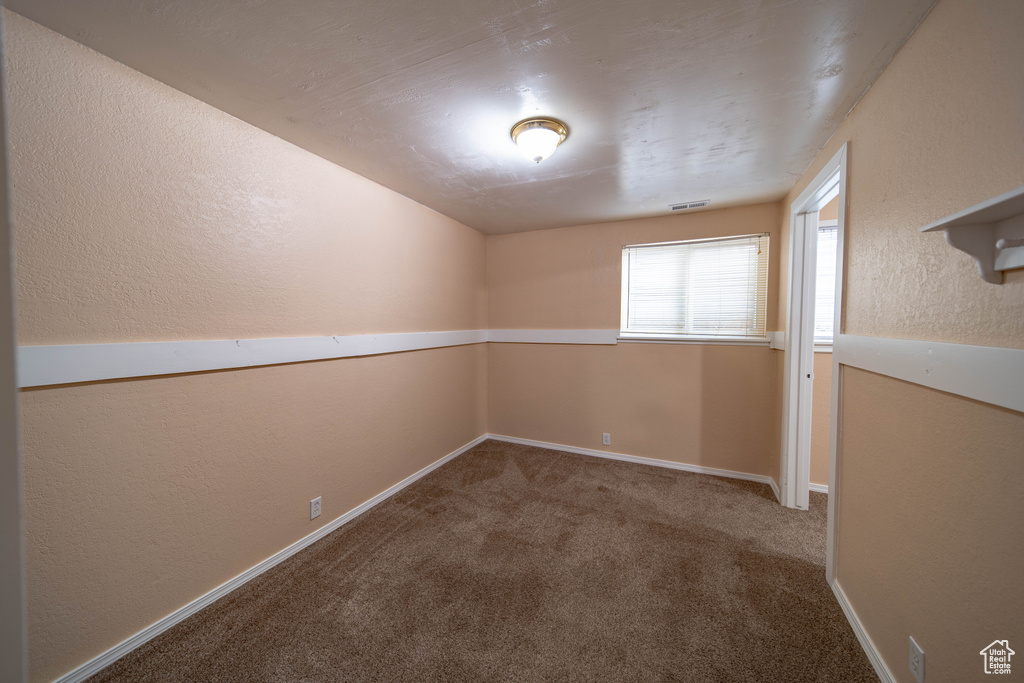 Spare room with carpet floors and a textured wall
