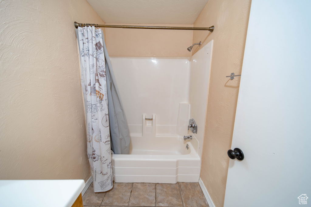 Full bathroom with shower / bathtub combination with curtain and tile patterned floors