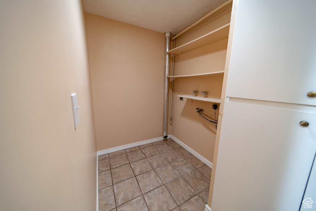 Walk in closet with light tile patterned flooring
