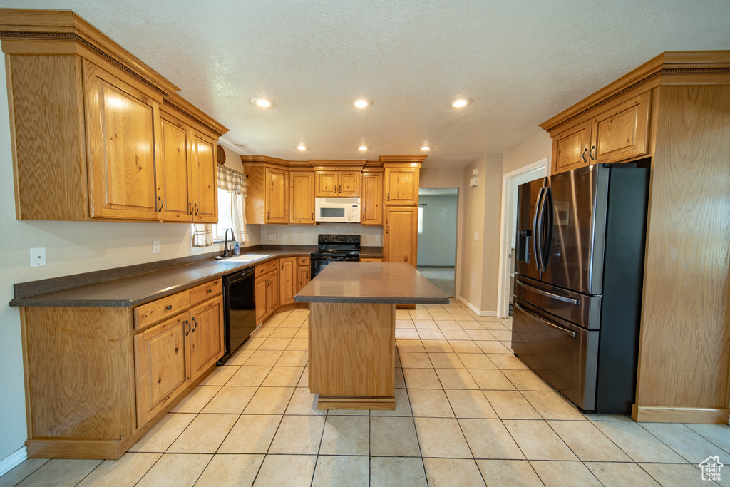 Kitchen with black appliances, dark countertops, a kitchen island, recessed lighting, and light tile patterned flooring