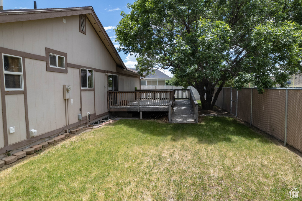 Fenced backyard featuring a deck