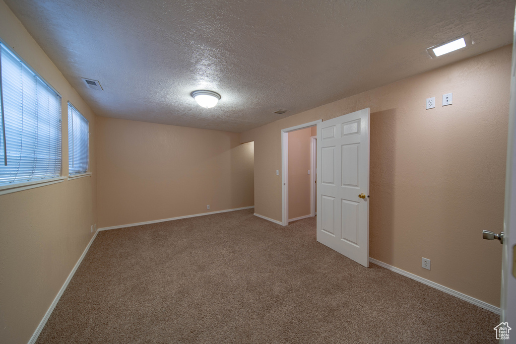 Unfurnished bedroom with a textured ceiling and carpet floors