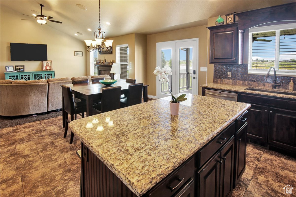 Kitchen featuring a sink, open floor plan, dishwasher, decorative backsplash, and a chandelier
