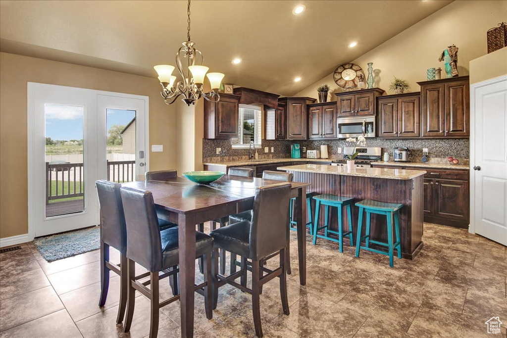 Dining area with lofted ceiling, a chandelier, and recessed lighting