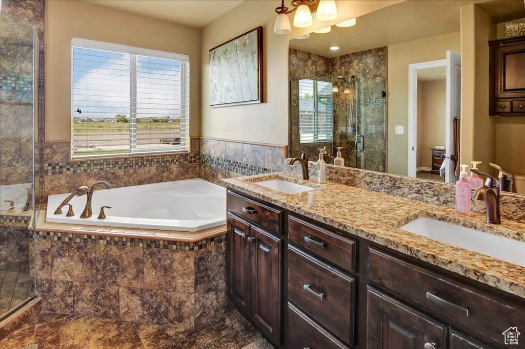 Bathroom featuring toilet, a stall shower, a garden tub, and double vanity