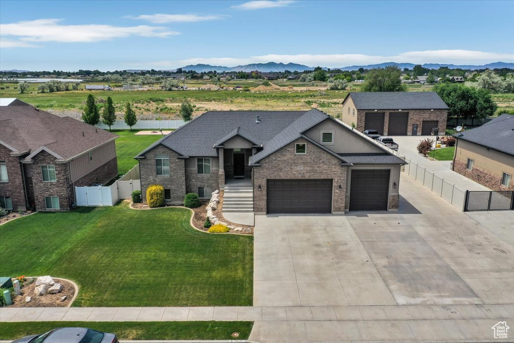 View of front facade featuring a gate, driveway, central AC unit, brick siding, and a mountain view