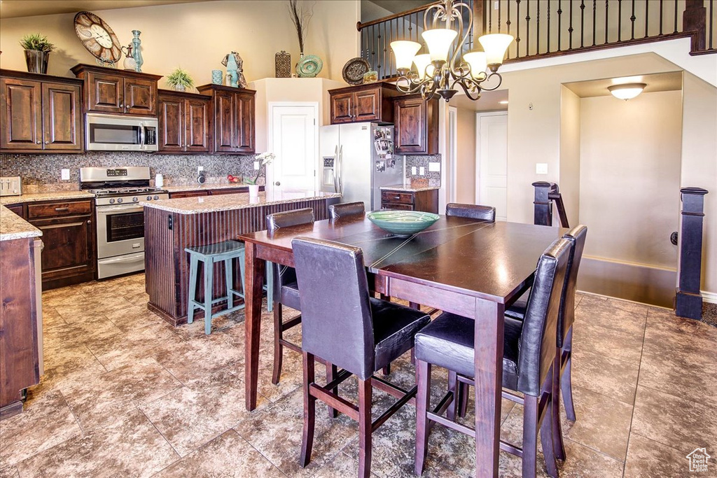 Dining area featuring a towering ceiling and a chandelier