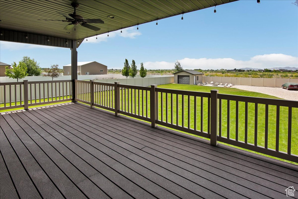 Wooden deck featuring a ceiling fan and an outbuilding