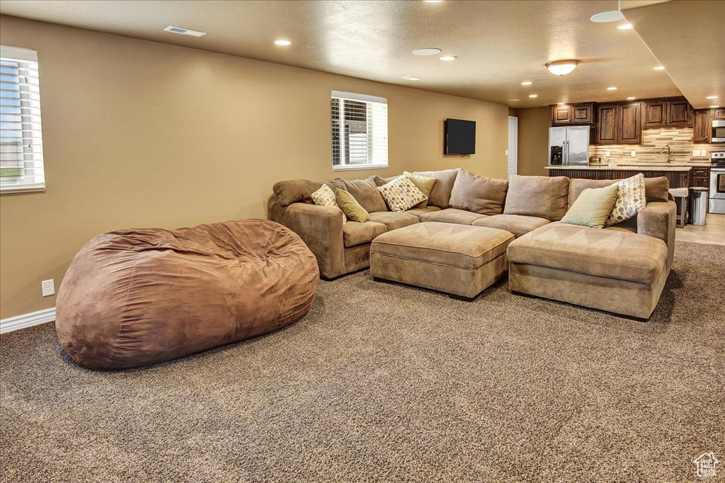 Living room featuring recessed lighting, baseboards, and light carpet