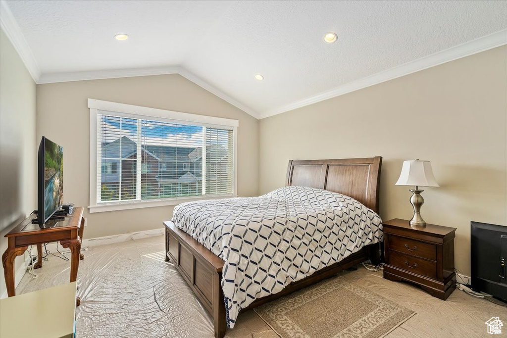 Bedroom with light colored carpet, ornamental molding, lofted ceiling, baseboards, and recessed lighting