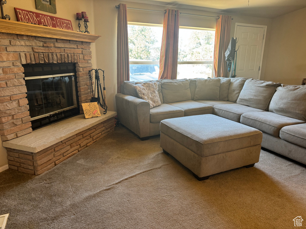Carpeted living area featuring a brick fireplace