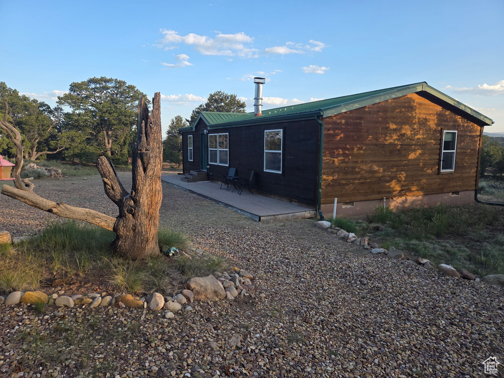 View of side of property with a metal roof and crawl space