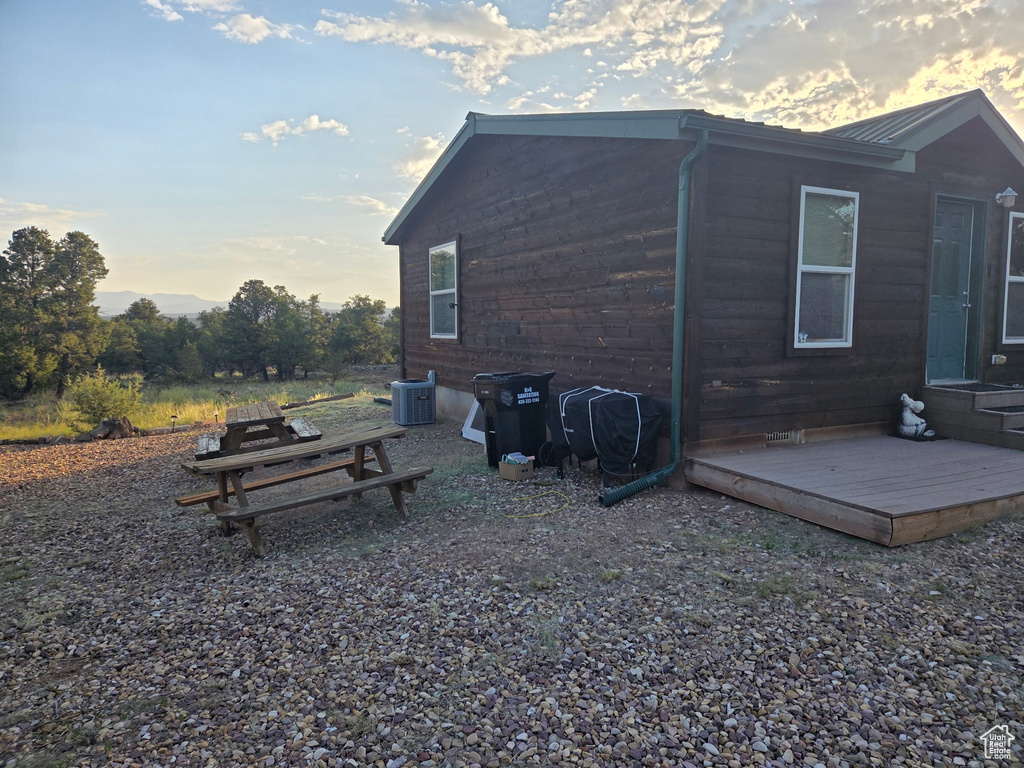 View of side of home with a wooden deck and a metal roof