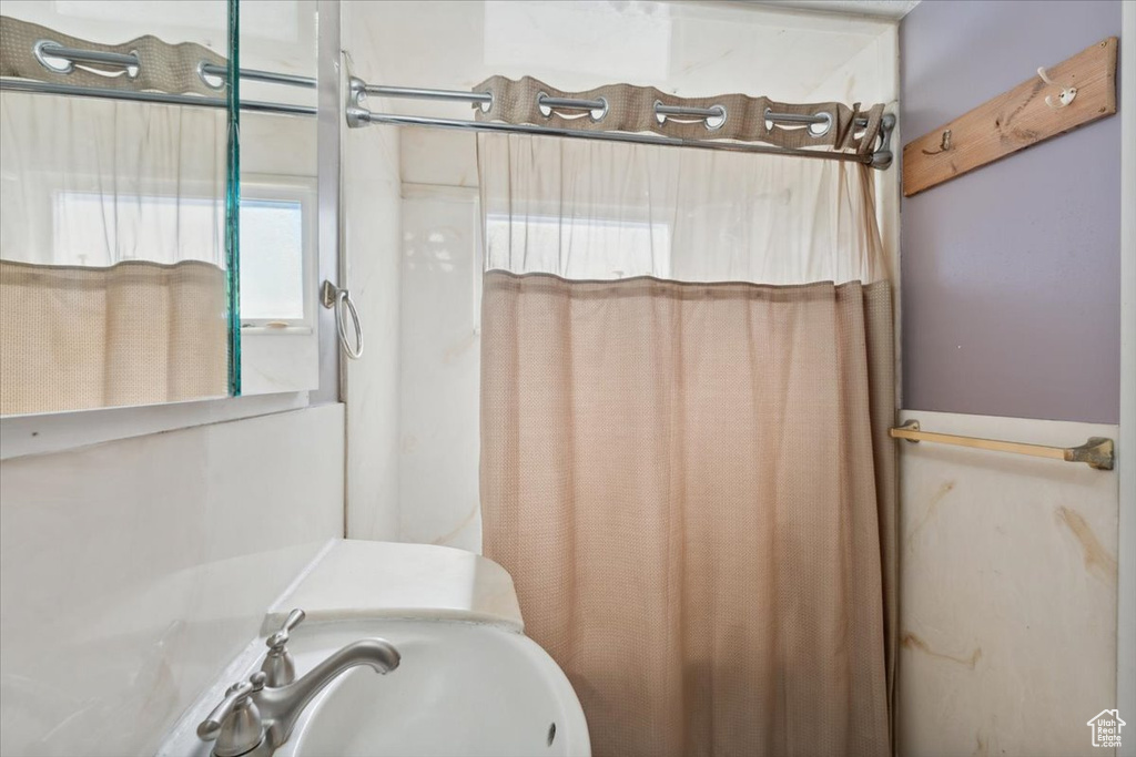 Full bathroom featuring curtained shower and a sink