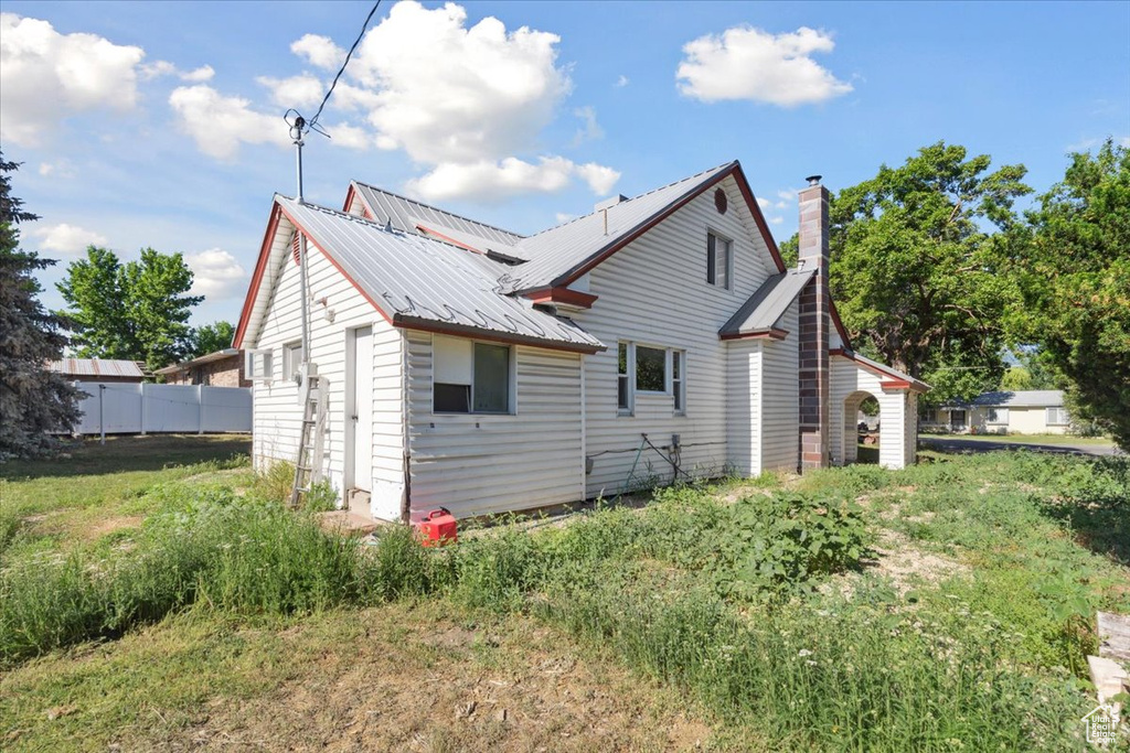 Rear view of house with a metal roof and a chimney