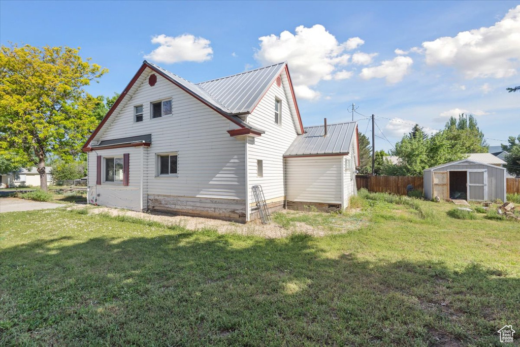 Back of house featuring a shed and a metal roof