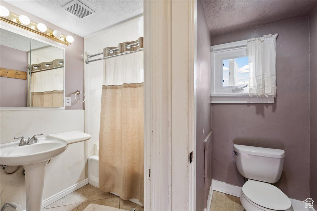 Bathroom with shower / bath combo with shower curtain and a textured ceiling
