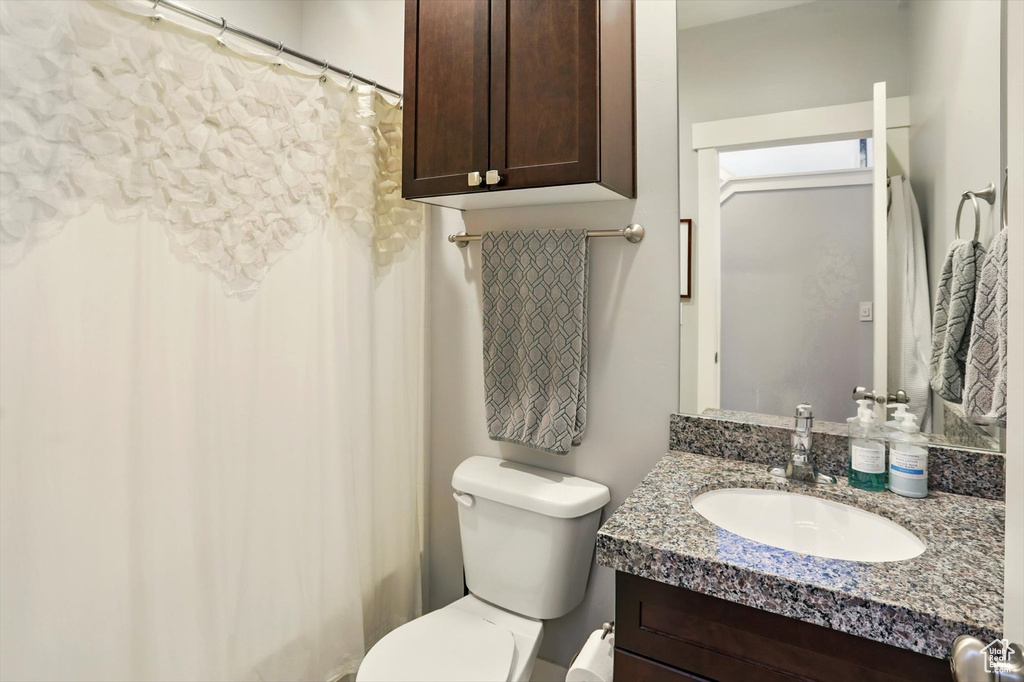Bathroom featuring vanity, toilet, and a shower with curtain