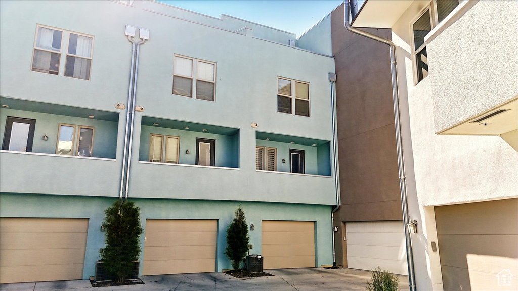 Rear view of house featuring a garage and stucco siding