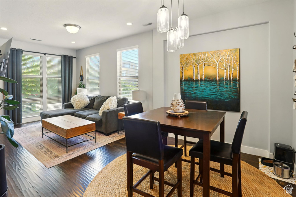 Dining space with plenty of natural light, dark wood-type flooring, and recessed lighting