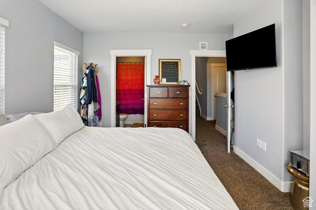 Bedroom featuring dark carpet and baseboards