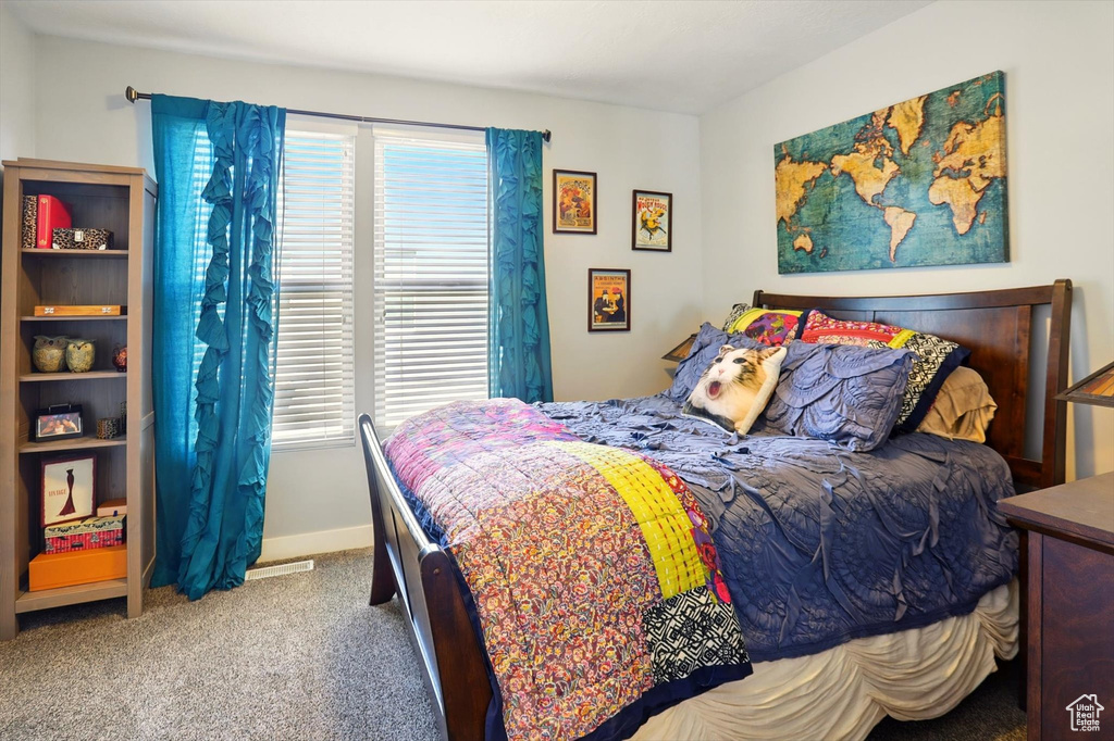 Carpeted bedroom featuring multiple windows and baseboards