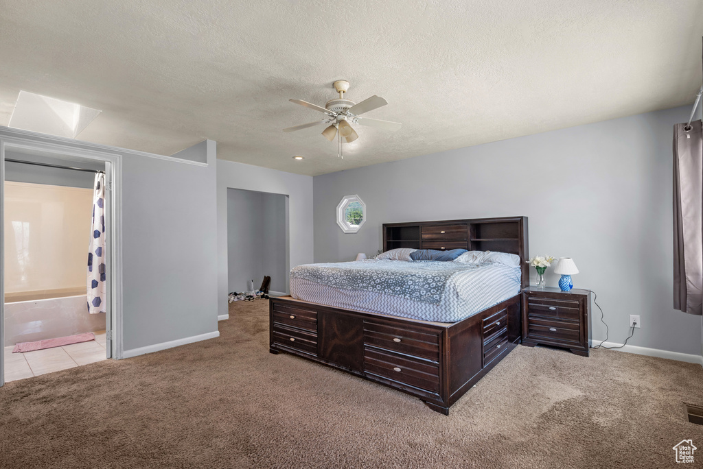 Bedroom with carpet, baseboards, a ceiling fan, and a textured ceiling