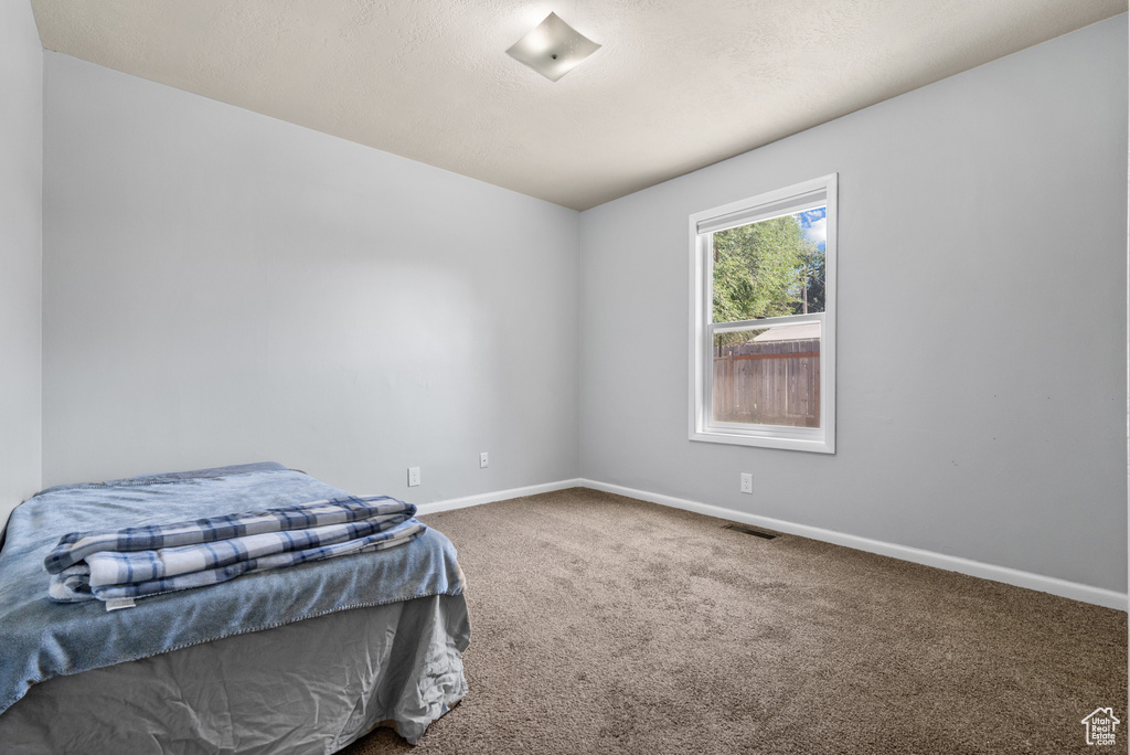 Carpeted bedroom featuring baseboards