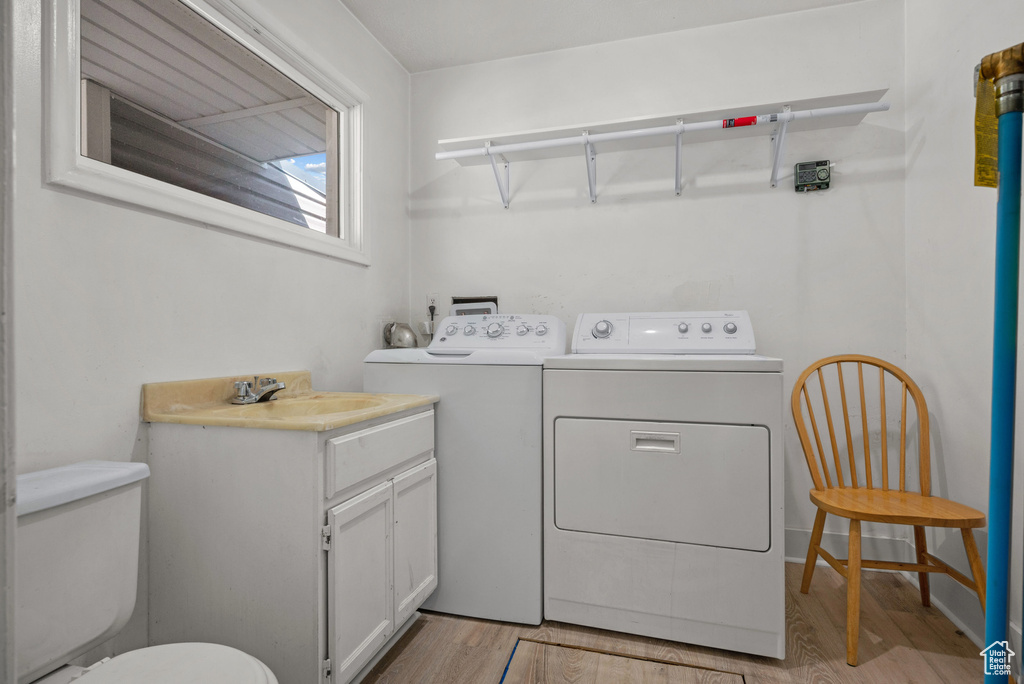 Laundry room featuring independent washer and dryer and light wood-type flooring