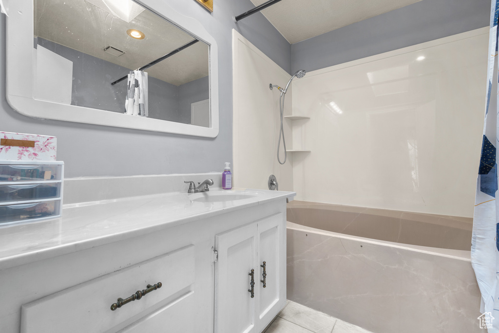 Full bathroom featuring shower / bath combination with curtain, vanity, and tile patterned flooring