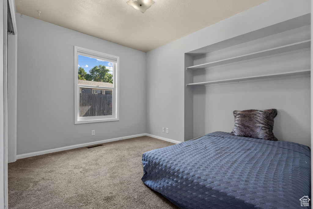Bedroom featuring carpet and baseboards