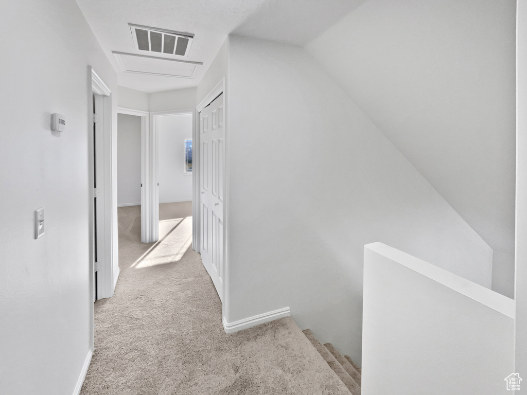 Hall with carpet and an upstairs landing
