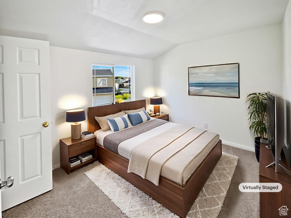 Bedroom with carpet flooring and lofted ceiling