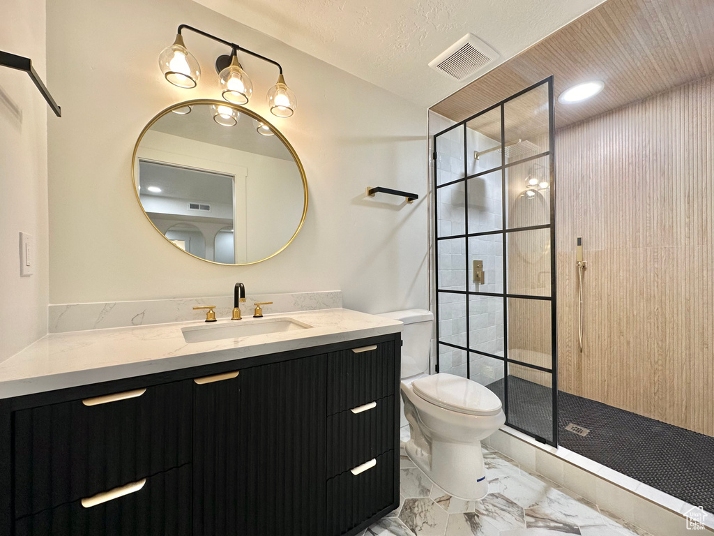 Full bath featuring marble finish floors, vanity, and a shower stall